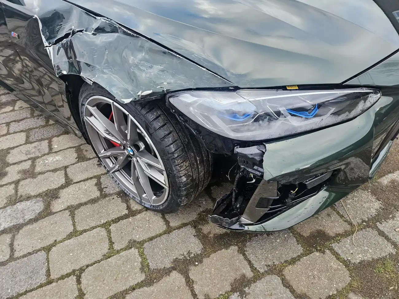 Unfallschaden im Detail: aufgerissener Stoßfänger und deformierter Kotflügel am BMW M440i