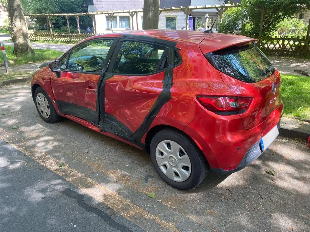 Roter Renault Clio mit Seitenschaden an den Türen