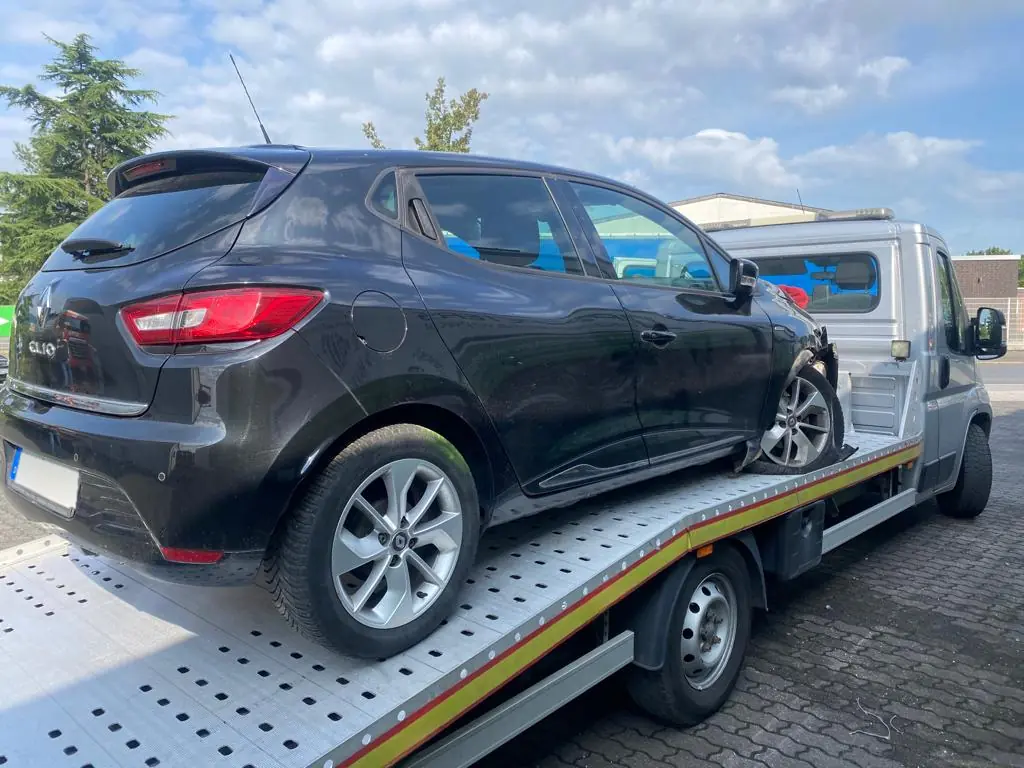 Schwarzer Renault Clio mit Unfallschaden auf dem Abschleppwagen