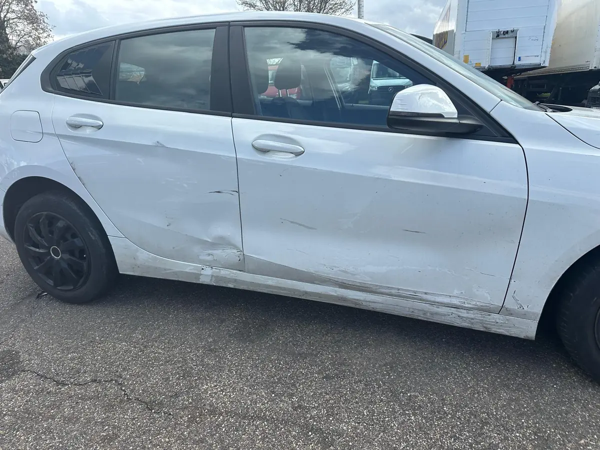 Weißer BMW 1er mit Seitenschaden an den Türen