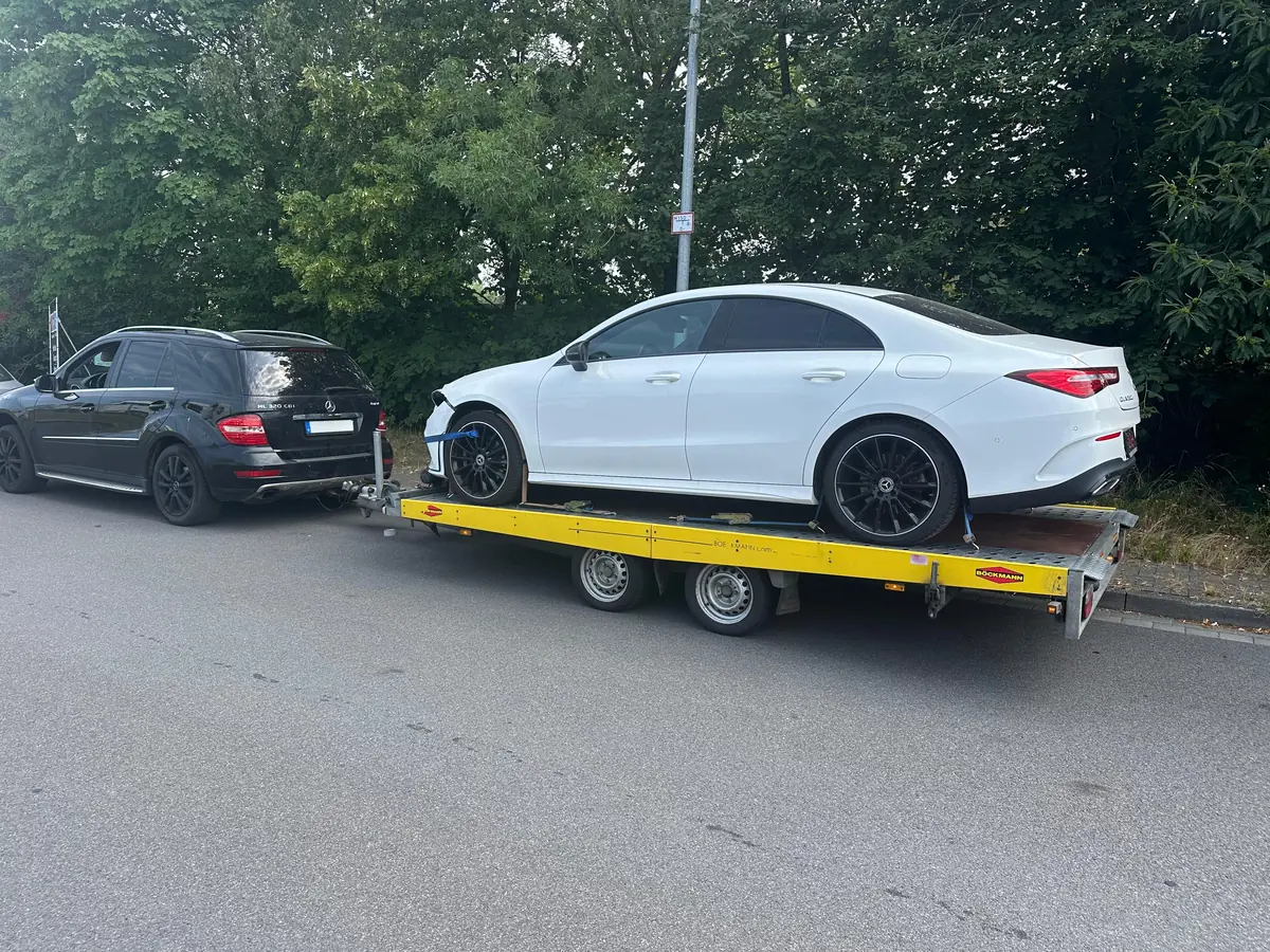 Abholung beim Unfallwagen-Ankauf: Mercedes ML mit Autoanhänger, darauf ein Mercedes CLA