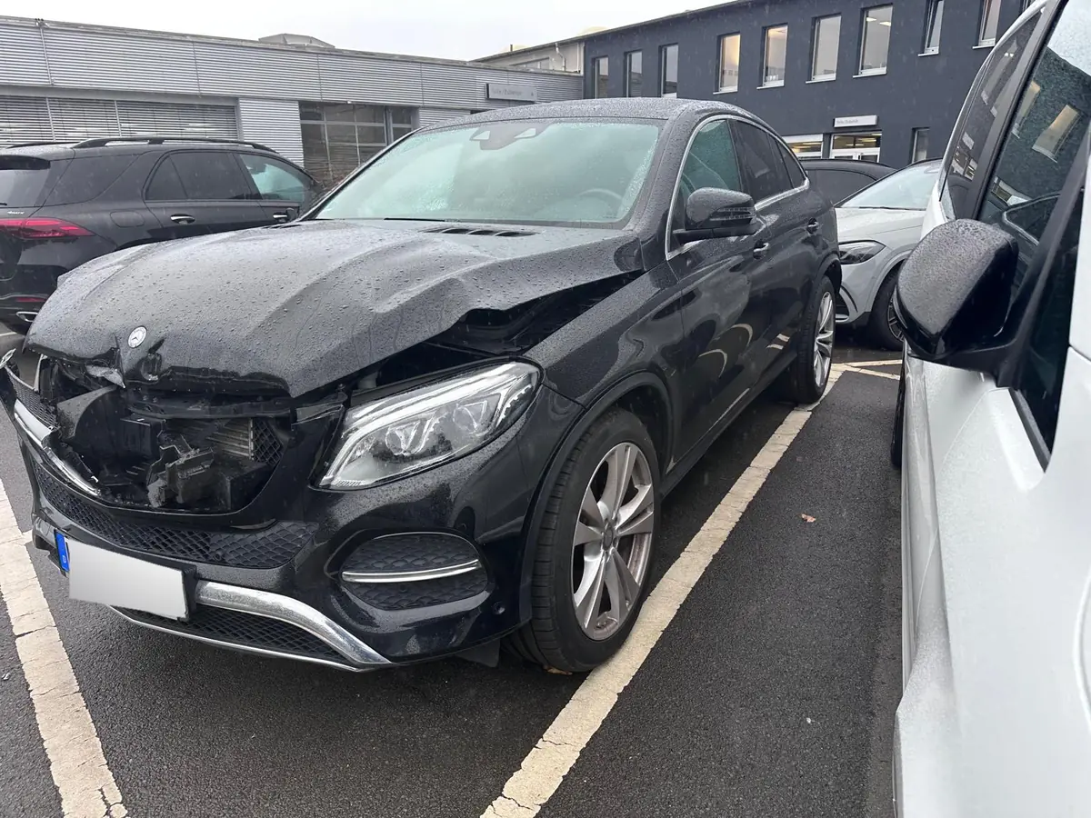Schwarzer Mercedes GLE Coupé mit schwerem Frontschaden: Motorhaube verbogen, Stoßfänger und Kühlerbereich zerstört