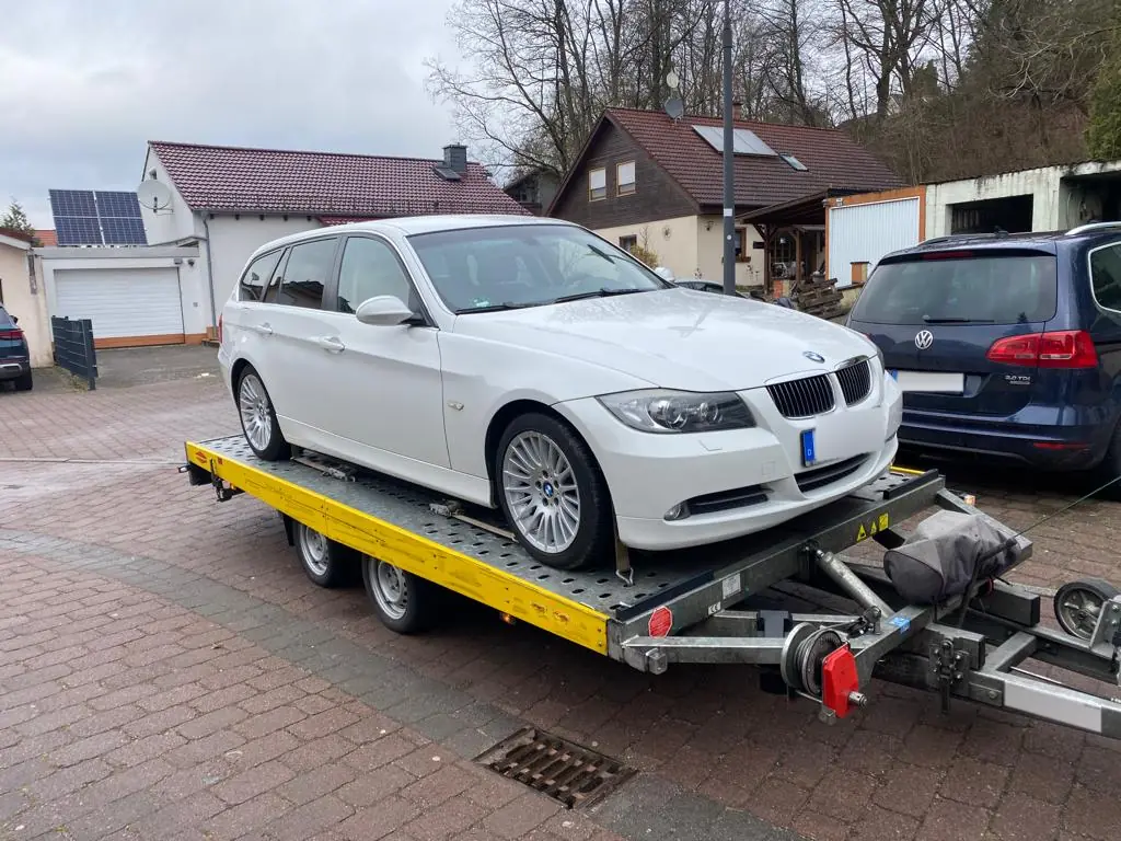 Weißer BMW 3er Touring auf unserem Autoanhänger bei der Abholung