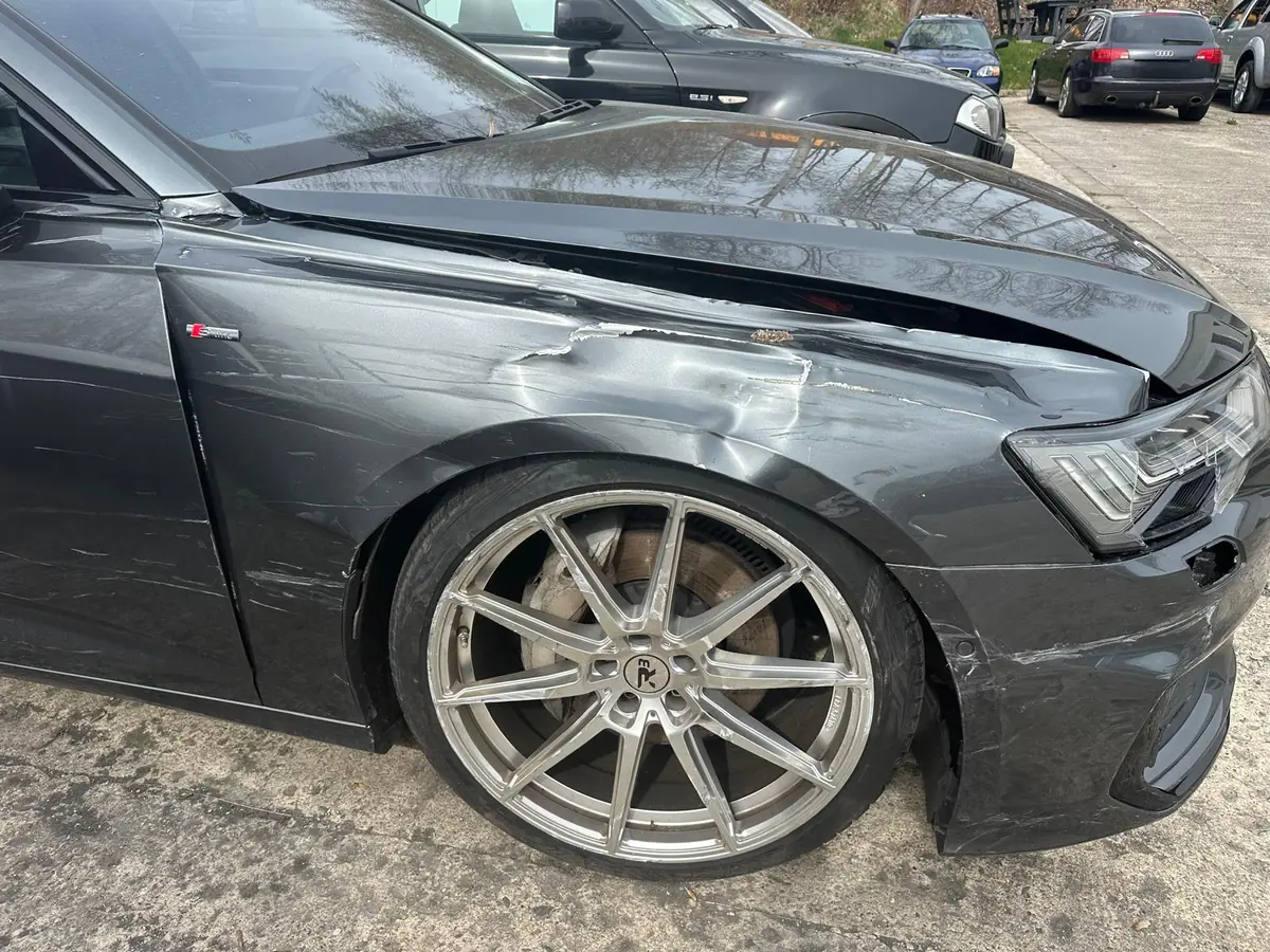 Grauer Audi A6 mit Schaden an Kotflügel, Scheinwerfer und Stoßfänger vorne rechts